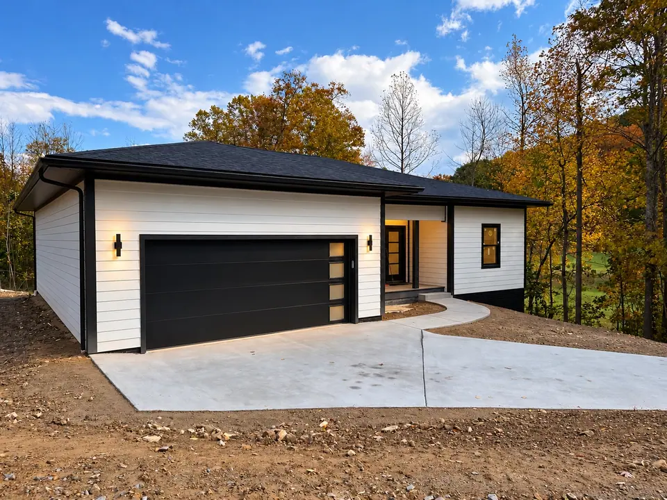 Close view of the front of 202 King Drive with black garage door and concrete driveway