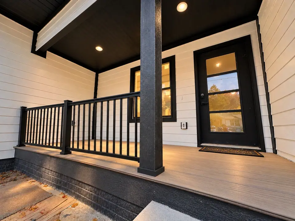 Covered front porch at 202 King Drive with black railing and black front door