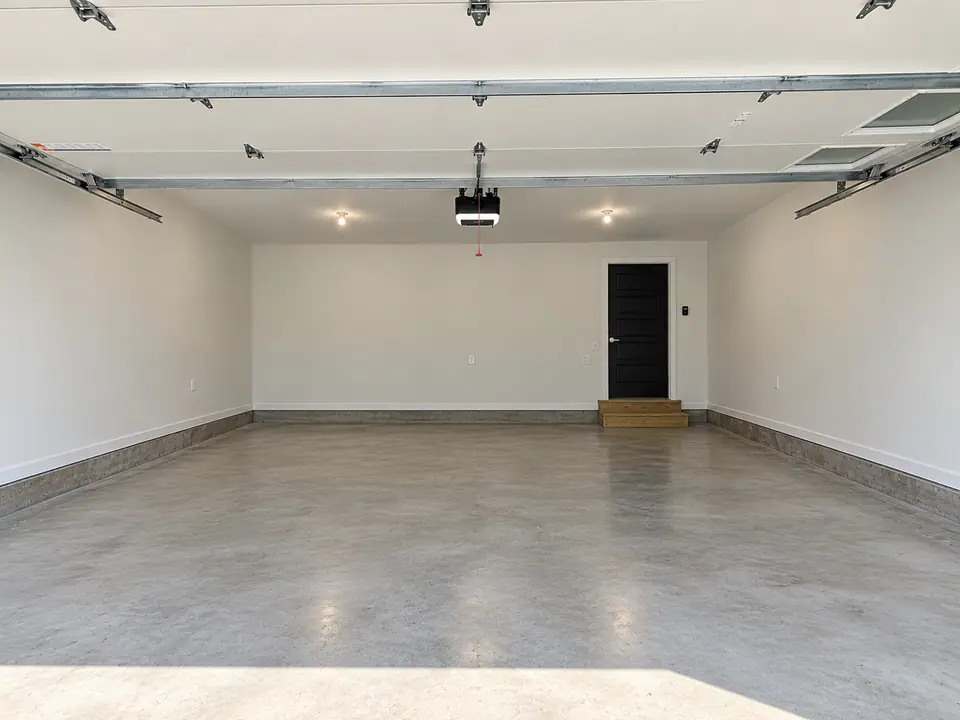 Garage interior looking toward the rear wall and door, with concrete floor